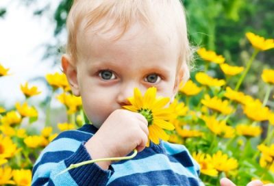 Ребенок нюхает цветок